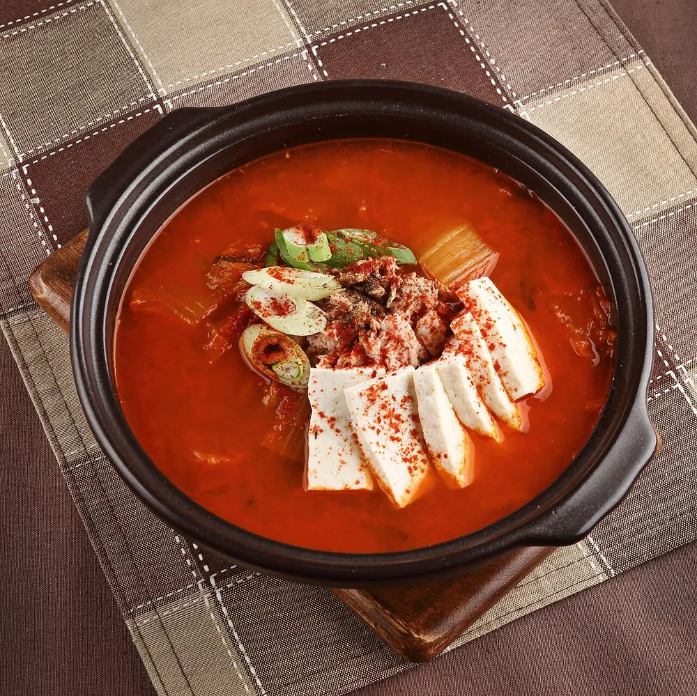 A bubbling pot of kimchi-jjigae with tofu and pork